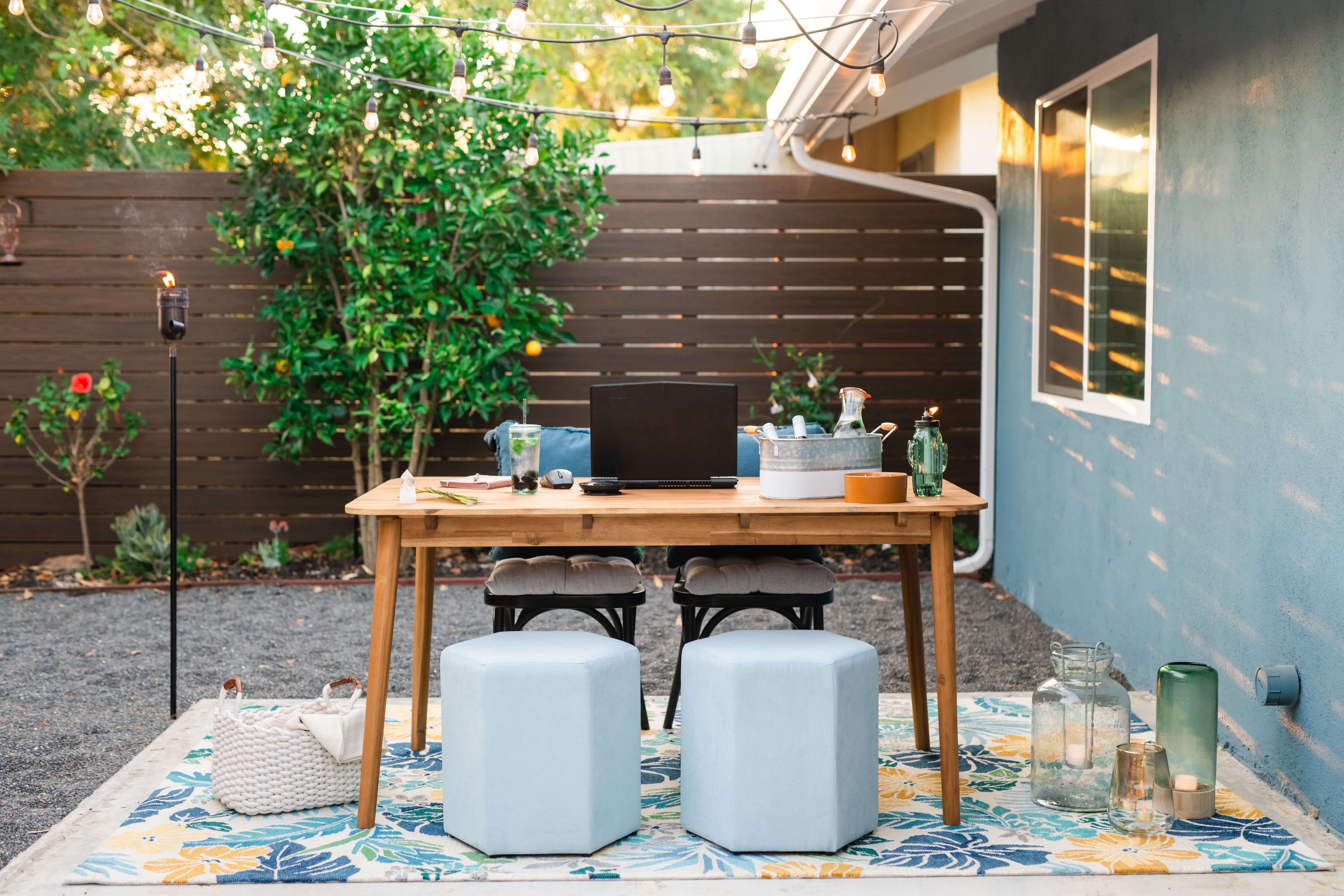 Cozy backyard office setup with string lights and outdoor seating.