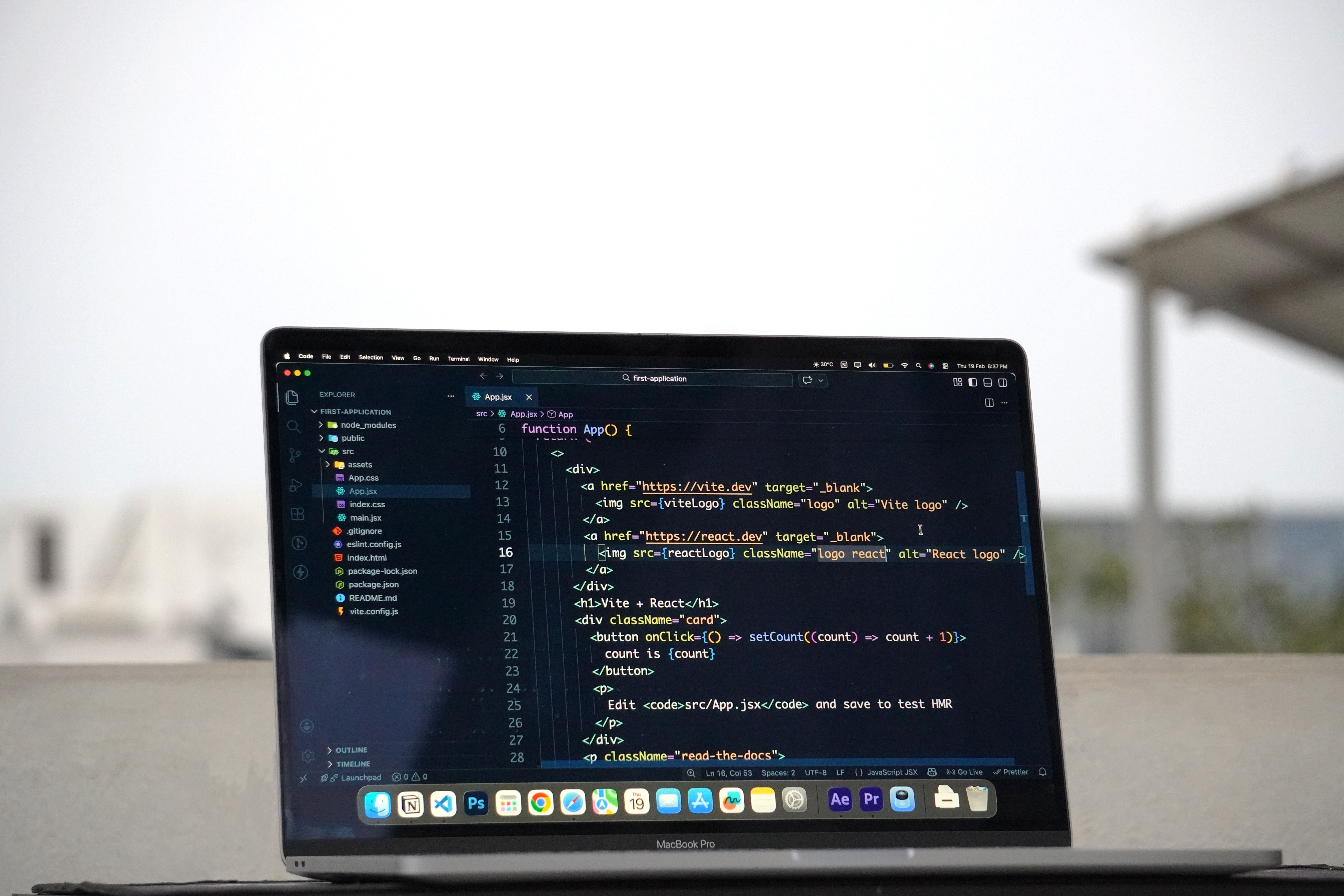 Laptop displaying code on a terrace, illustrating outdoor work for a developer.
