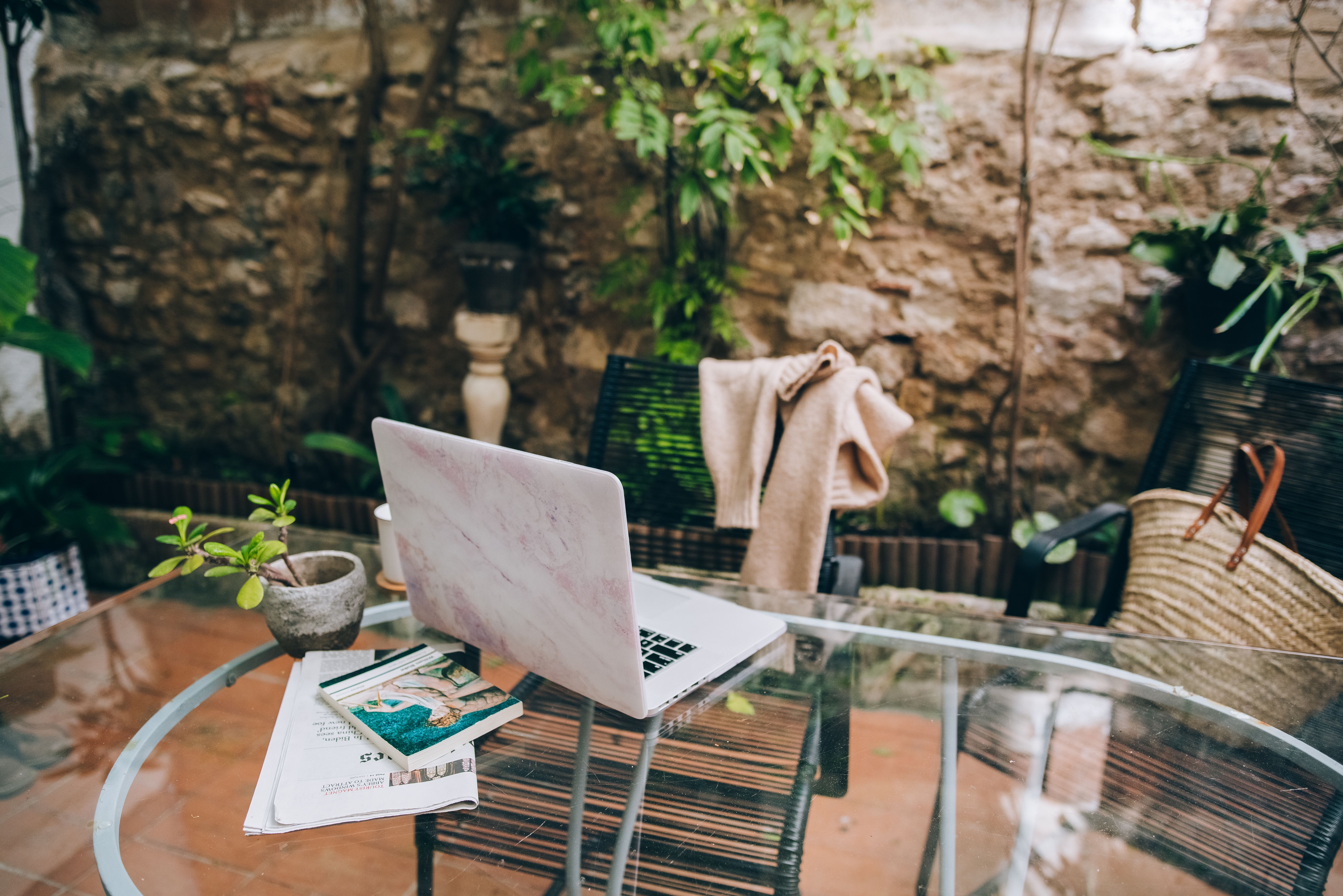 Laptop, plants, and comfortable seating in a serene outdoor home office.